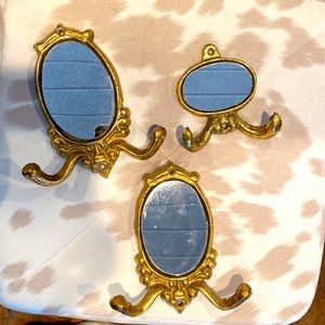 Set/3 mirrored heavy metal wall hooks. Gold in finish.